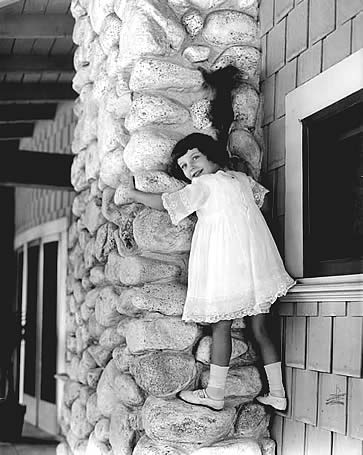 Marie climbing outside chimney at her residence with a pet monkey