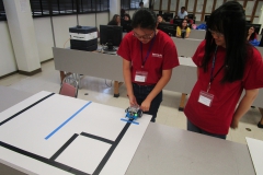 Student setting her robot at the start line for the competition